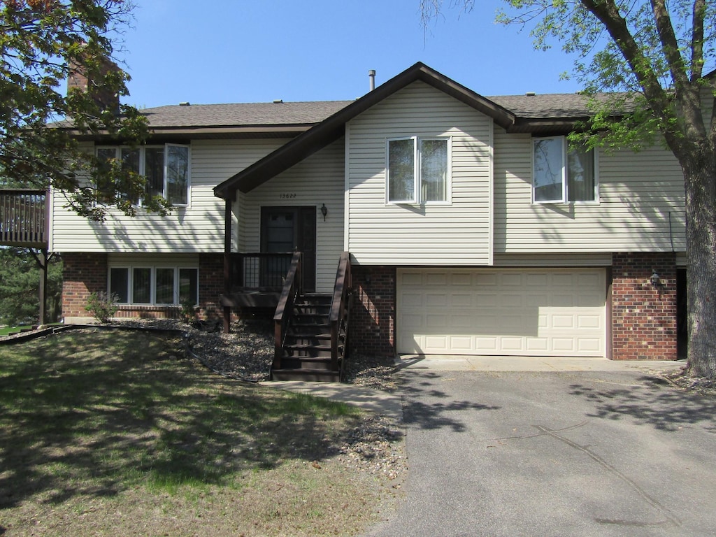 13622 Knox Dr, Burnsville, MN 55337 - split foyer home featuring brick siding, an attached garage, driveway, and a chimney