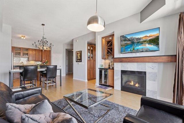 500 Grant St Unit 2509, Minneapolis, MN 55404 - living area with light wood finished floors, a chandelier, a tiled fireplace, and baseboards