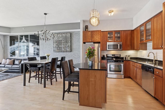 500 Grant St Unit 2509, Minneapolis, MN 55404 - kitchen with stainless steel appliances, a chandelier, a sink, light wood-style floors, and a textured ceiling