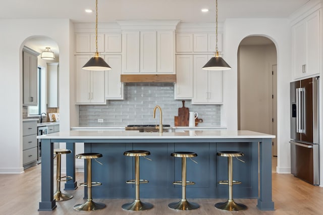 10382 Peony Ln N, Maple Grove, MN 55311 - kitchen with high quality fridge, arched walkways, light countertops, backsplash, and recessed lighting