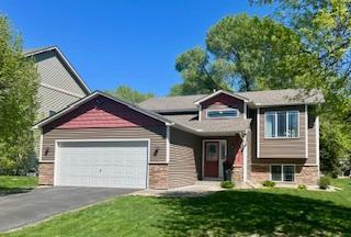 view of front of property with an attached garage, asphalt driveway, and a front yard