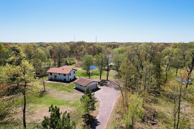 aerial view of property and surrounding area featuring a heavily wooded area