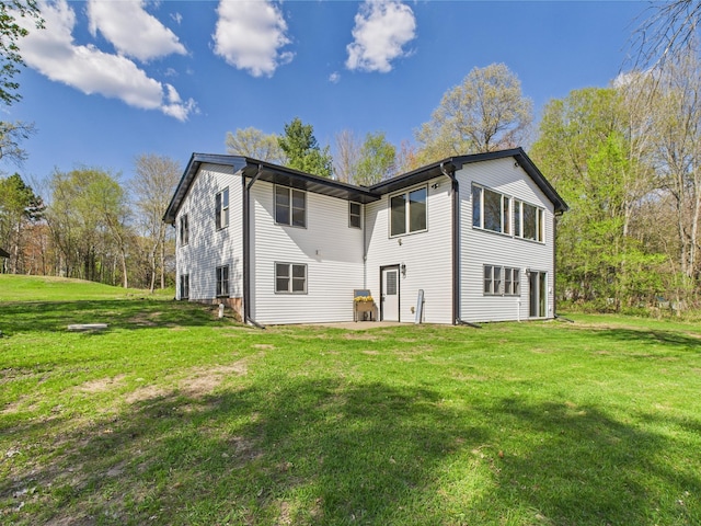 rear view of house featuring a lawn and a patio area