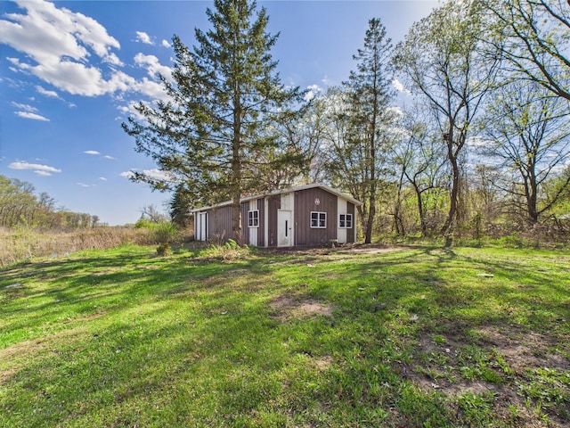 view of grassy yard with an outdoor structure