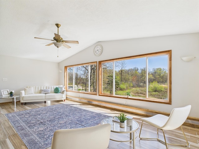 living room with vaulted ceiling, ceiling fan, wood finished floors, and baseboards