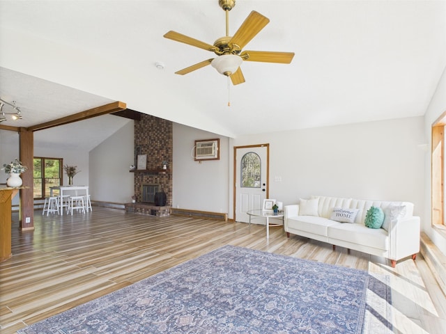 living area featuring lofted ceiling, wood finished floors, ceiling fan, a brick fireplace, and a wall mounted air conditioner
