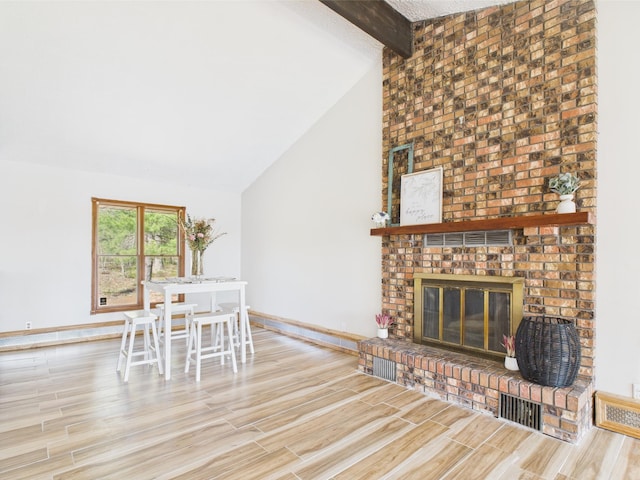 dining room with wood finished floors, a fireplace, and baseboards