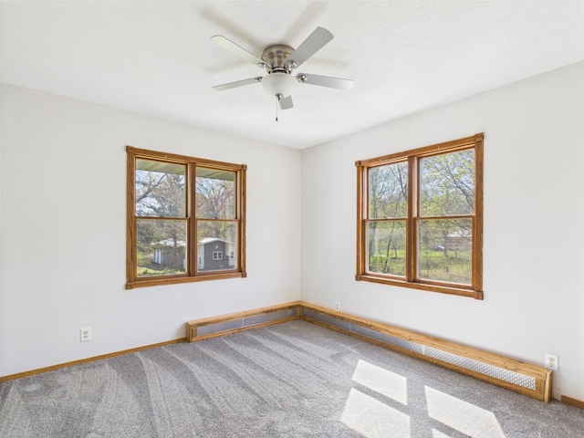 spare room with carpet flooring, baseboards, and ceiling fan