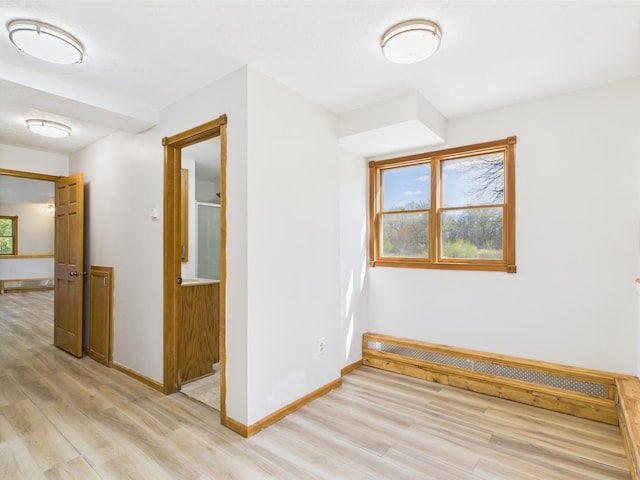 bonus room with light wood-style flooring and baseboards