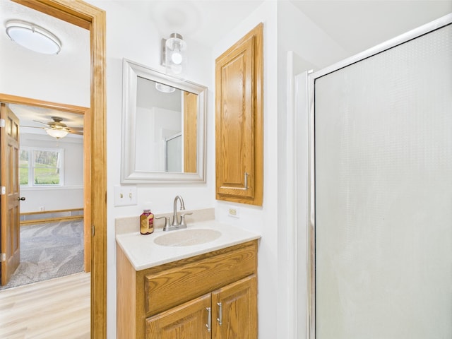 bathroom with wood finished floors, an enclosed shower, vanity, and a ceiling fan