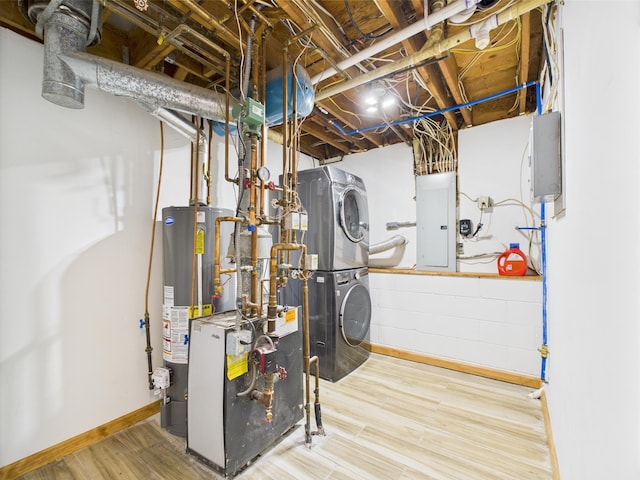 utilities featuring estacked washer and dryer, water heater, electric panel, and a heating unit