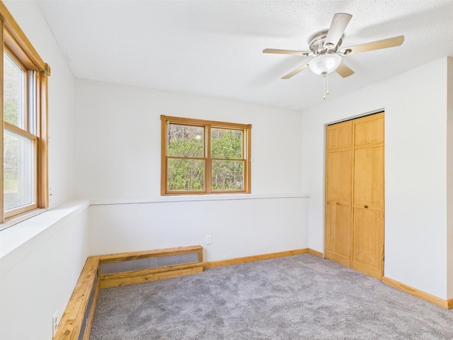 unfurnished bedroom featuring carpet flooring, baseboards, a ceiling fan, and a closet