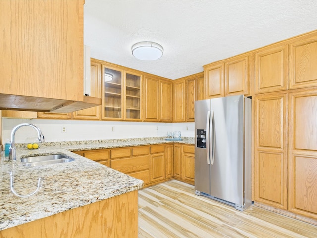 30145 Fir Trl, Stacy, MN 55079 - kitchen with stainless steel fridge, light stone counters, light wood finished floors, and glass insert cabinets