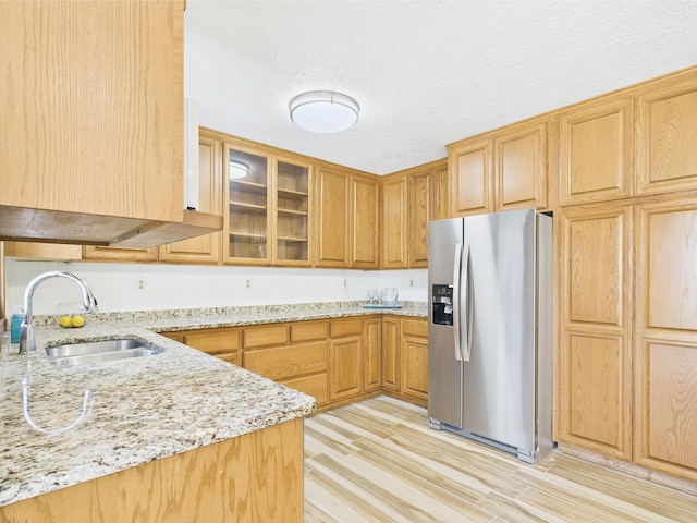 30145 Fir Trl, Stacy, MN 55079 - kitchen featuring stainless steel fridge, light stone countertops, light wood-type flooring, and glass insert cabinets