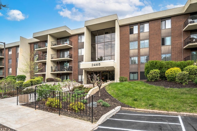 2465 Londin Ln E Unit 212, Maplewood, MN 55119 - view of apartment building / complex featuring uncovered parking and fence