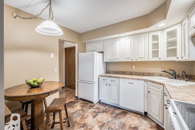 2465 Londin Ln E Unit 212, Maplewood, MN 55119 - kitchen with white appliances, a sink, glass insert cabinets, light countertops, and decorative light fixtures