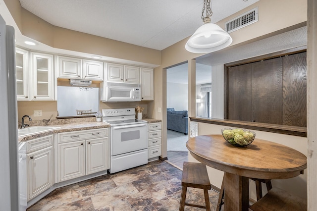 2465 Londin Ln E Unit 212, Maplewood, MN 55119 - kitchen with white appliances, a sink, light countertops, white cabinets, and stone finish flooring