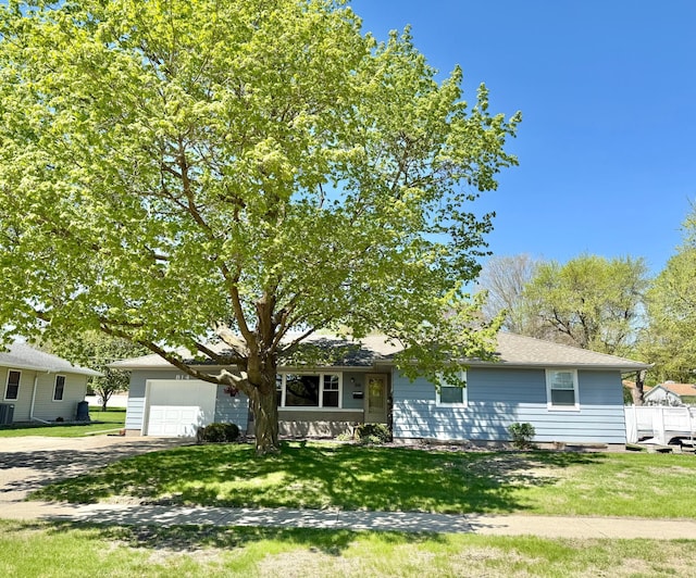 view of front of property featuring an attached garage, asphalt driveway, and a front yard