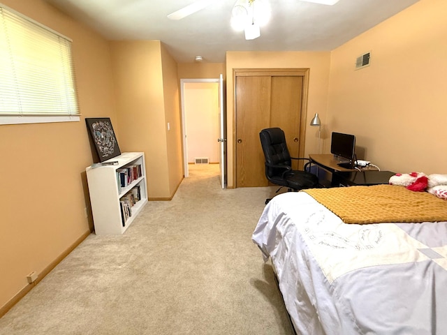 carpeted bedroom with a closet, ceiling fan, and a desk