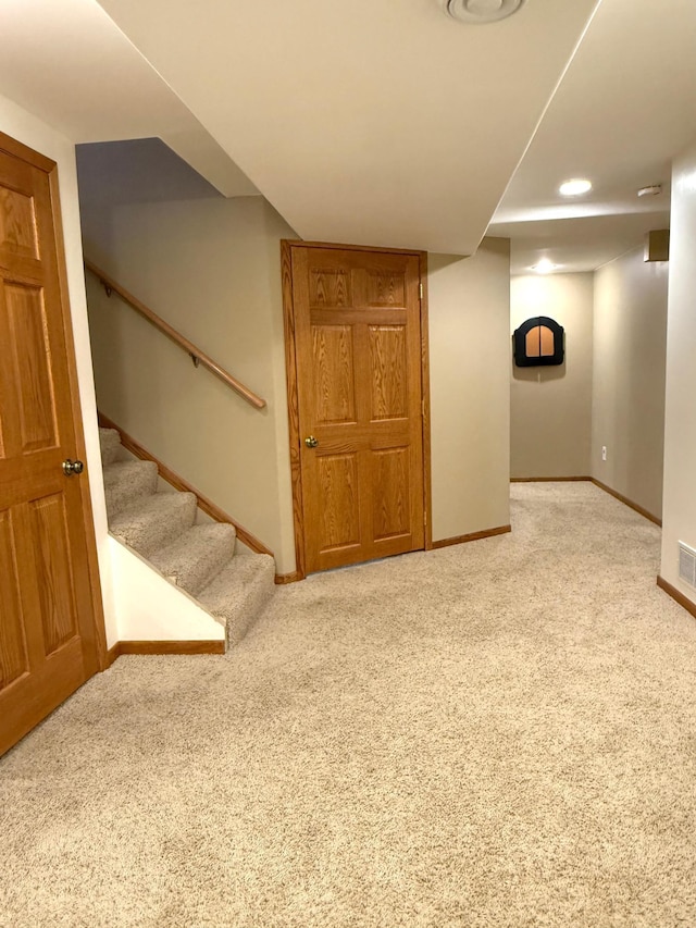 finished basement with carpet floors, baseboards, and stairs