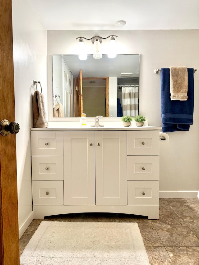 bathroom with baseboards, vanity, and curtained shower