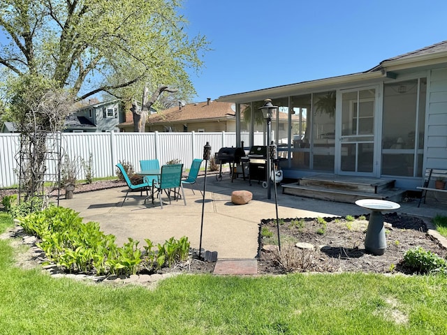view of patio / terrace featuring a sunroom and fence