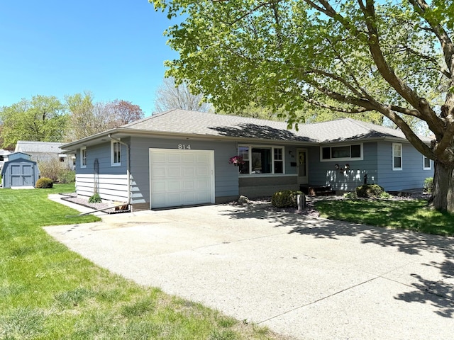 view of front facade featuring an attached garage, a storage shed, a front lawn, concrete driveway, and an outdoor structure