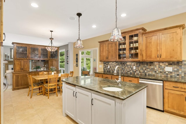 6209 Heather Pl NE, Fridley, MN 55432 - kitchen with stainless steel dishwasher, a sink, decorative backsplash, a center island with sink, and glass insert cabinets