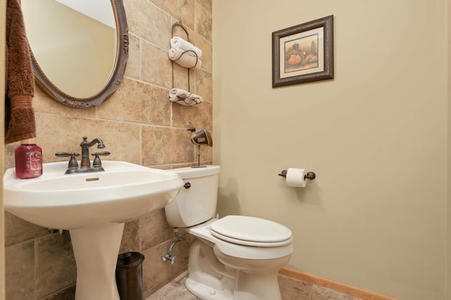 6209 Heather Pl NE, Fridley, MN 55432 - bathroom with toilet, tile walls, a sink, baseboards, and backsplash