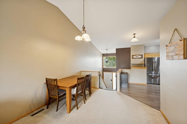 8260 Parkington Ave NE, Otsego, MN 55330 - dining area featuring lofted ceiling, baseboards, wood finished floors, and a chandelier