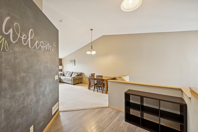 8260 Parkington Ave NE, Otsego, MN 55330 - hallway with wood finished floors, vaulted ceiling, and a chandelier