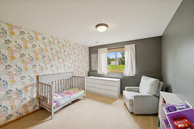 8260 Parkington Ave NE, Otsego, MN 55330 - bedroom with carpet flooring, a textured ceiling, a nursery area, and wallpapered walls