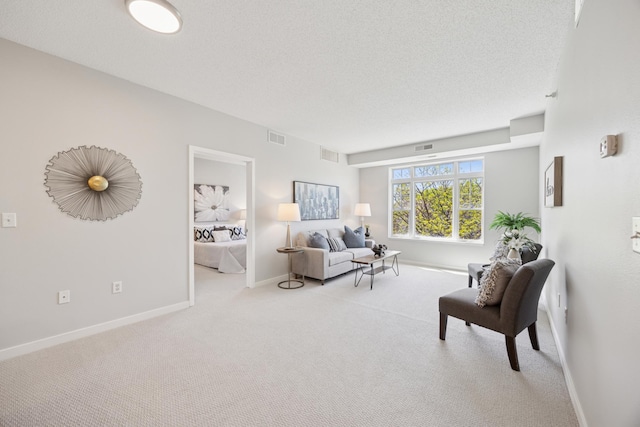 carpeted living room with baseboards and a textured ceiling