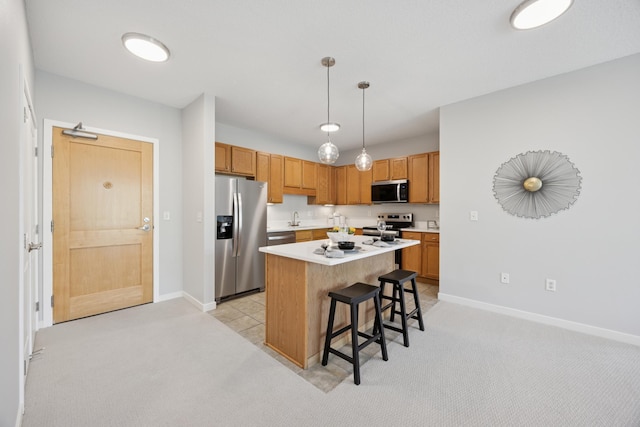 kitchen featuring appliances with stainless steel finishes, a kitchen bar, baseboards, and light colored carpet