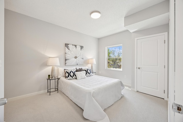 carpeted bedroom with baseboards and a textured ceiling