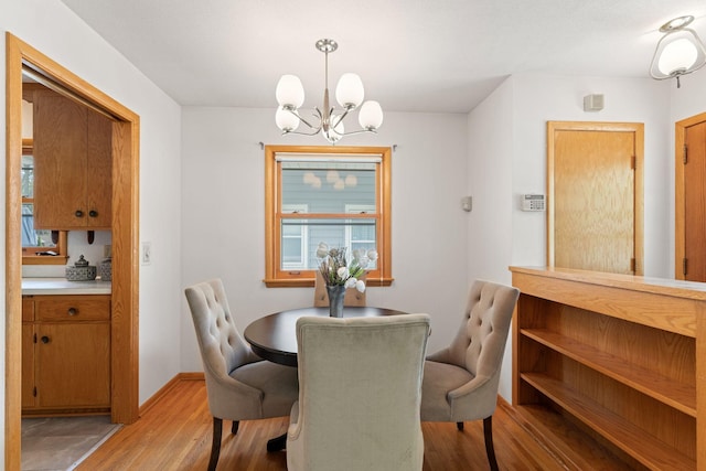 dining space featuring a chandelier and light wood-style flooring