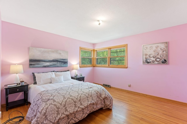 bedroom with wood finished floors and baseboards