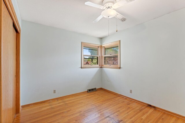 empty room featuring light wood finished floors, ceiling fan, and baseboards