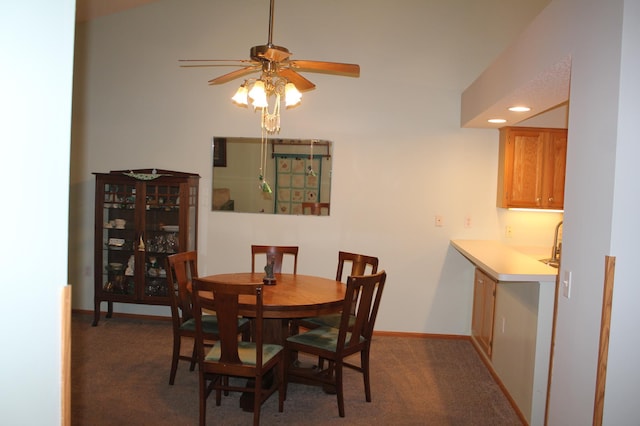 carpeted dining room with a ceiling fan and baseboards