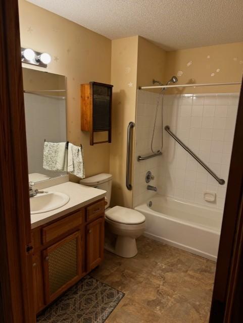 full bath featuring a textured ceiling, toilet, vanity, and shower / washtub combination