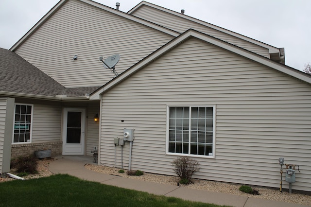 back of property with a shingled roof