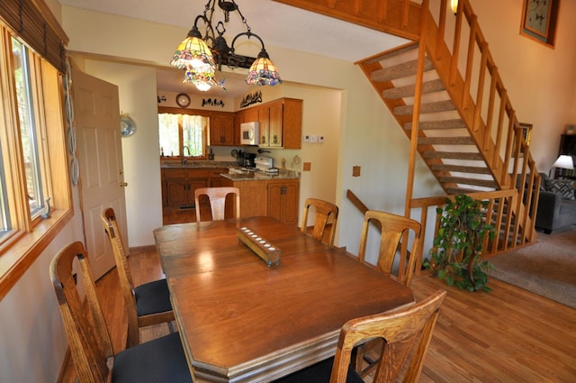 dining space featuring light wood finished floors and stairway