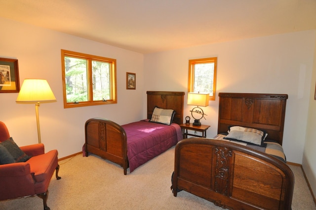carpeted bedroom featuring multiple windows and baseboards