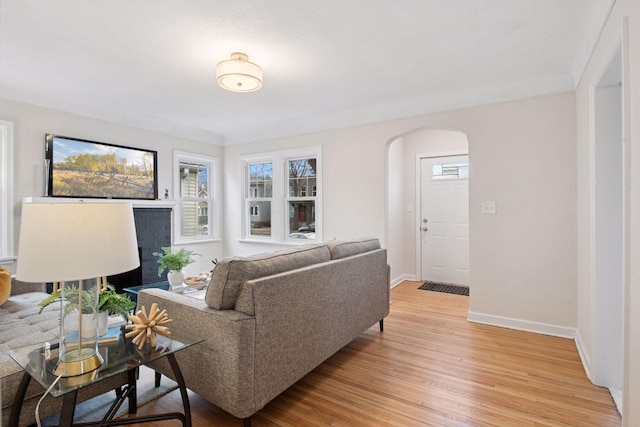1650 Sherburne Ave, Saint Paul, MN 55104 - living area with arched walkways, light wood-style flooring, baseboards, and plenty of natural light