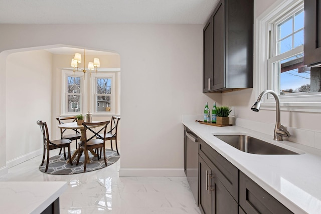 1650 Sherburne Ave, Saint Paul, MN 55104 - kitchen featuring a sink, stainless steel dishwasher, light marble finish floors, and baseboards