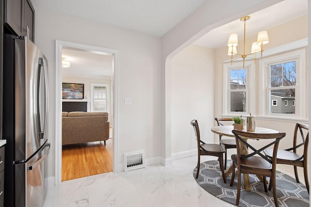 1650 Sherburne Ave, Saint Paul, MN 55104 - dining area with marble finish floors, a chandelier, and baseboards
