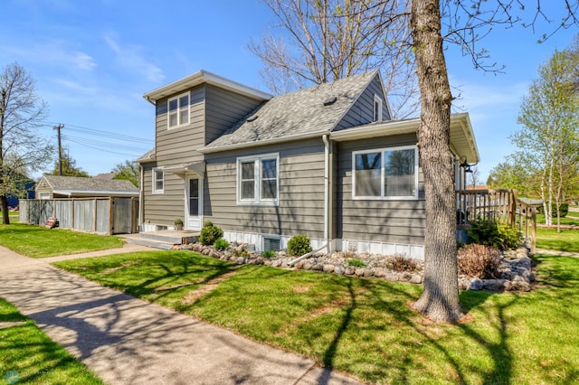 101 5th St NE, Barnesville, MN 56514 - view of front of house featuring a front yard, a shingled roof, an outbuilding, and a deck