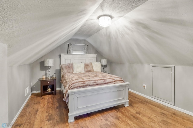 101 5th St NE, Barnesville, MN 56514 - bedroom with a textured ceiling, wood finished floors, lofted ceiling, and baseboards