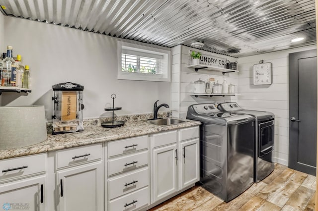101 5th St NE, Barnesville, MN 56514 - laundry room featuring washing machine and clothes dryer, light wood-style flooring, and cabinet space