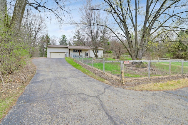 W12798 State Road 35, Prescott, WI 54021 - view of front facade with an attached garage, asphalt driveway, a fenced front yard, and stucco siding